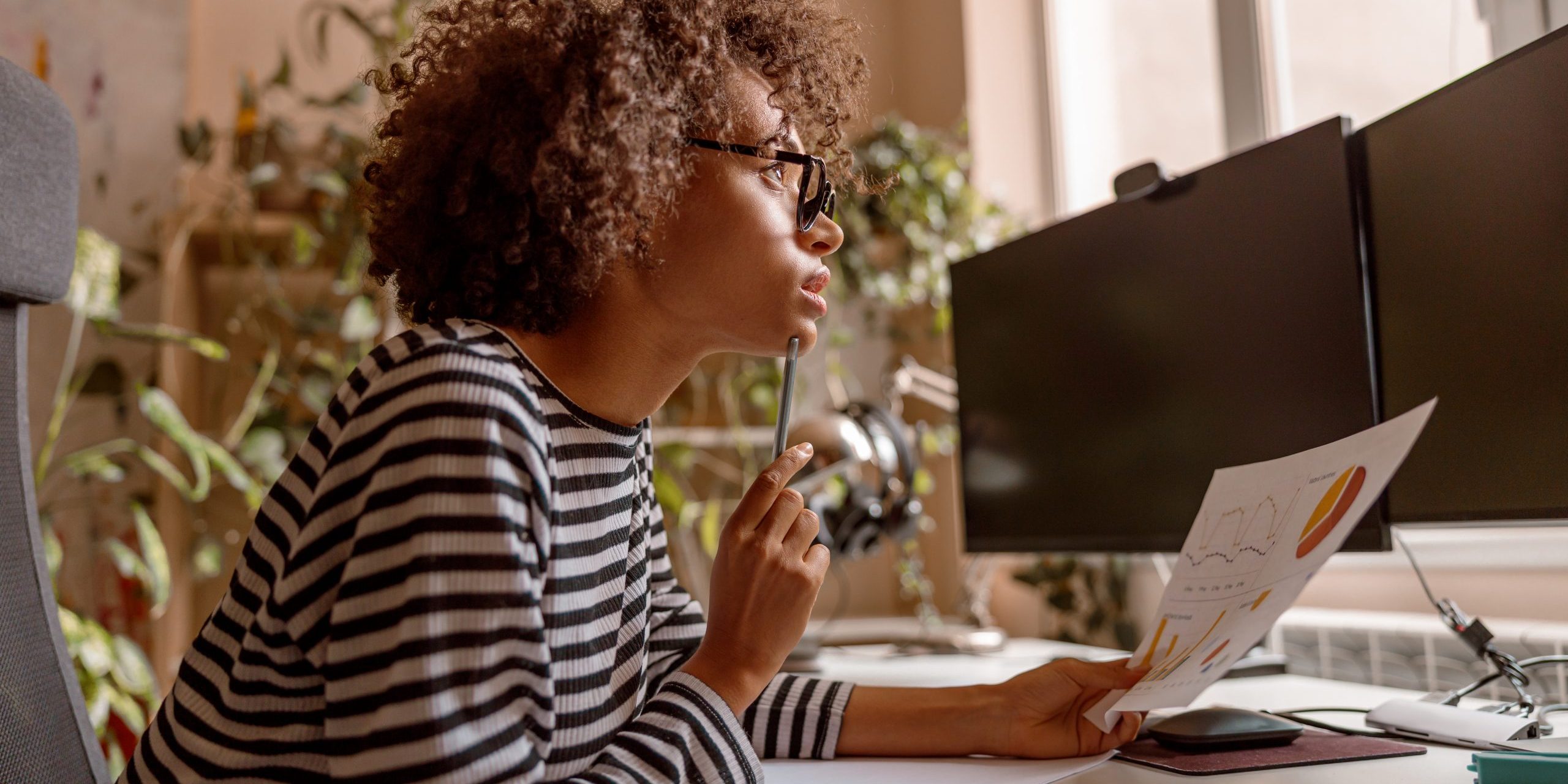 Young woman studying papers and working on project at home